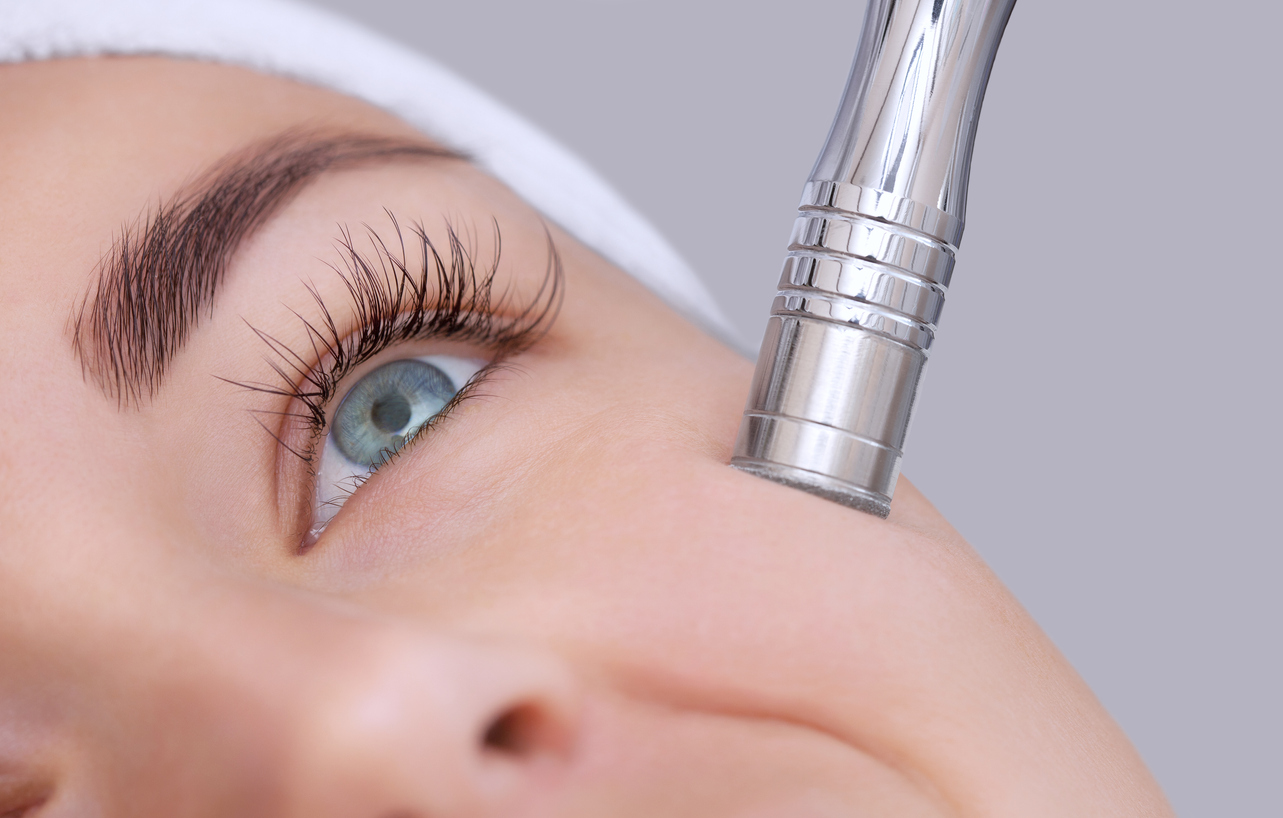 Femeie care își face tratament facial cu aparat microabraziune
