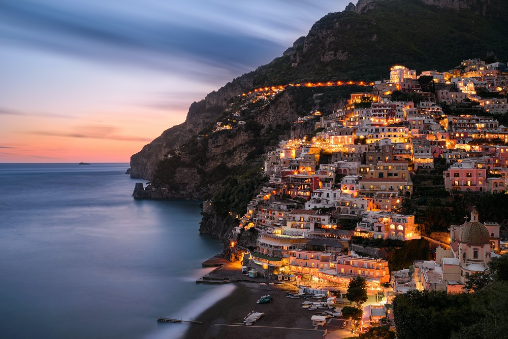 Clădiri luminate pe malul mării în Italia.