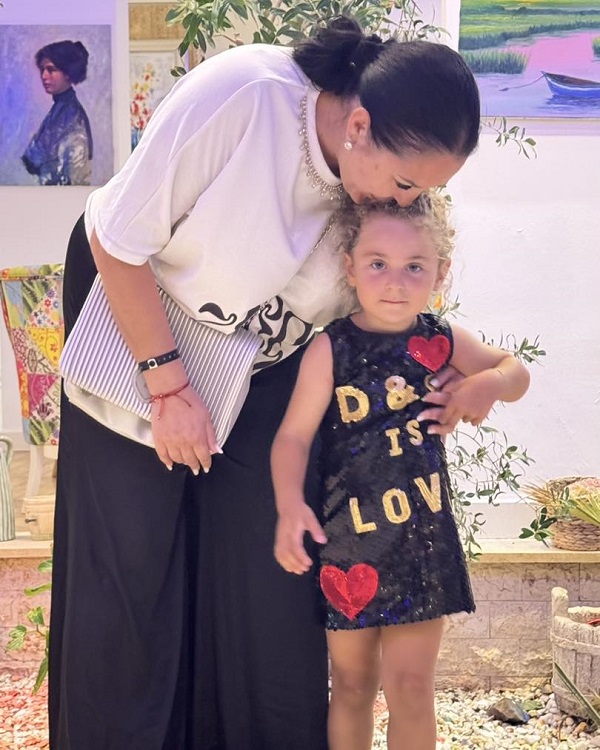 angela rusu isi saruta fata imbracata in rochie neagra pe frunte